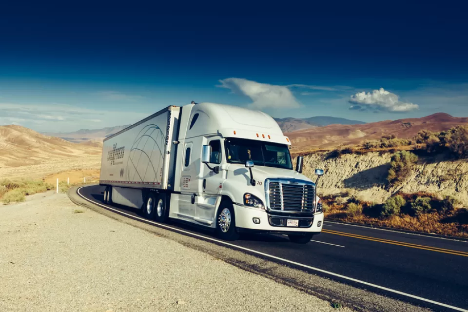Diesel big rig truck on California road with mountains in background